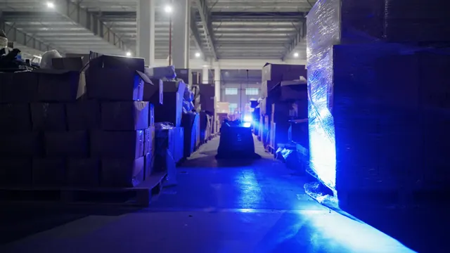 Gausium Beetle varrendo galpão com luz azul de sinalização acesa