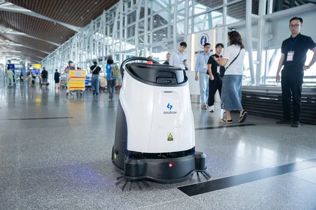 Gausium Scrubber 50 lavando saguão de aeroporto entre passageiros